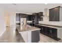 Bright kitchen with stainless steel appliances, dark cabinets, gray countertop, and a large island at 2364 N 212Th Ave, Buckeye, AZ 85396