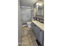 Well-lit bathroom featuring a walk-in shower with glass doors and gray cabinets at 25 S 102Nd St # 92, Mesa, AZ 85208