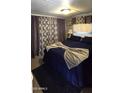 Cozy bedroom with dark blue bedding, carpet and window with privacy curtains at 25 S 102Nd St # 92, Mesa, AZ 85208