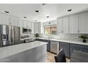 Bright kitchen featuring two-tone cabinets, stainless steel appliances, and an island with a quartz countertop at 2893 W Five Mile Peak Rd, San Tan Valley, AZ 85144