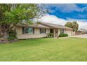 Charming single story home with well-maintained front yard featuring a beautiful flowering shade tree at 3010 E Cortez St, Phoenix, AZ 85028