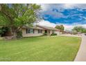 Charming single story home with well-maintained front yard featuring a beautiful flowering shade tree at 3010 E Cortez St, Phoenix, AZ 85028
