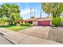 Single-story home featuring a tile roof, brick accents and a concrete driveway leading to a two-car garage at 3027 N Nebraska St, Chandler, AZ 85225
