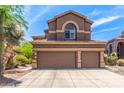 Exterior of a two-story home featuring a three-car garage, tile roof and desert landscaping at 3055 N Red Mountain -- # 98, Mesa, AZ 85207
