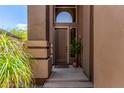 Front door of a home with a stone facade, desert landscaping, and a small tree in a basket at 3055 N Red Mountain -- # 98, Mesa, AZ 85207