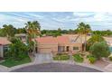 Aerial view showcases a well-maintained property with a tile roof, palm trees and landscaped circular driveway at 306 E Sarah Ln, Tempe, AZ 85284