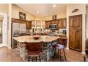 A kitchen with stone-clad island, stainless steel appliances, granite countertops, and wood cabinetry at 30844 N 41St Pl, Cave Creek, AZ 85331