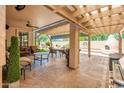 Covered patio featuring stone flooring, comfortable seating, a built-in fireplace, and views of the landscaped yard at 30844 N 41St Pl, Cave Creek, AZ 85331