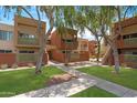Exterior view of multiple units with well-maintained landscaping and mature shade trees in a courtyard setting at 3500 N Hayden Rd # 2110, Scottsdale, AZ 85251