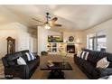 Comfortable living room with a fireplace, ceiling fan, neutral colors, and cozy seating perfect for relaxation at 3658 E Pony Track Ln, San Tan Valley, AZ 85140