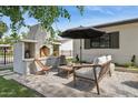 Inviting outdoor patio features a brick fireplace, comfortable seating, and a stylish umbrella at 4215 E Flower St, Phoenix, AZ 85018