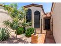 Charming stucco home entrance with tiled courtyard and a decorative wrought-iron security gate at 4313 N 29Th Way, Phoenix, AZ 85016