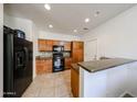 Well-equipped kitchen with black appliances, granite counters, and wooden cabinets at 451 S Hawes Rd # 53, Mesa, AZ 85208