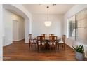 Formal dining room with hardwood floors, a round wooden table, and large windows providing natural light at 5832 E Bent Tree Dr, Scottsdale, AZ 85266