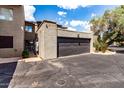 Two car garage with a black door and stucco siding, with an attached front parking area at 618 E Manzanita Pl, Phoenix, AZ 85020