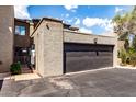 Two car garage with a black door and stucco siding, with an attached front parking area at 618 E Manzanita Pl, Phoenix, AZ 85020