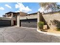 Two car garage with a black door and stucco siding, with an attached front parking area at 618 E Manzanita Pl, Phoenix, AZ 85020