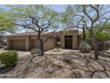 Inviting single-story home boasting desert landscaping and mature trees enhancing the curb appeal at 6917 E Night Glow Cir, Scottsdale, AZ 85266