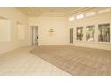 Bright living room featuring carpet and tile floors, tray ceilings, and large windows at 6917 E Night Glow Cir, Scottsdale, AZ 85266
