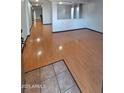 Spacious living room featuring laminate wood flooring that shines with a view to the hallway and front door at 7224 W Pioneer St, Phoenix, AZ 85043