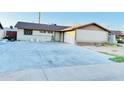 Home featuring a large driveway, attached garage, and lawn at 7940 W Avalon Dr, Phoenix, AZ 85033
