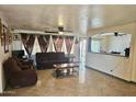 Inviting living room featuring tile floors, open layout, and backyard access at 7940 W Avalon Dr, Phoenix, AZ 85033