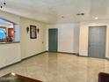 Bright living room with tile flooring, neutral walls, and gray doors at 7940 W Avalon Dr, Phoenix, AZ 85033