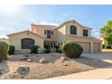Charming two-story home featuring a spacious driveway and a low-maintenance desert landscape at 9121 E Karen Dr, Scottsdale, AZ 85260