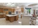 Spacious kitchen featuring an island with cooktop, breakfast bar, and lots of cabinet storage at 11403 E Caron St, Scottsdale, AZ 85259