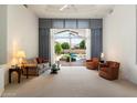 Bright living room featuring neutral carpet, modern decor, and a view of the backyard pool at 11403 E Caron St, Scottsdale, AZ 85259