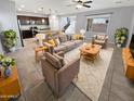 Spacious living room with tile flooring, neutral paint, a ceiling fan, and multiple seating arrangements at 12211 W Prickly Pear Trl, Peoria, AZ 85383