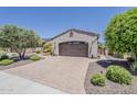 Attached two car garage with brick paved driveway and desert landscaping at 12738 W Brookhart Way, Peoria, AZ 85383