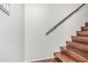 Staircase features sleek wood steps and a modern handrail, connecting levels elegantly at 1350 S Greenfield Rd # 2159, Mesa, AZ 85206