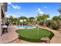 Inviting backyard featuring a sparkling pool, putting green and mature landscaping at 1365 N Drexel St, Mesa, AZ 85207