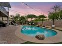 Inviting backyard with a pool, a stone waterfall, and string lights creating a relaxing ambiance at 1365 N Drexel St, Mesa, AZ 85207