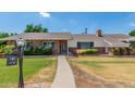 Charming single-story brick home with a well-manicured lawn and a welcoming pathway leading to the front door at 1407 E 1St St, Mesa, AZ 85203