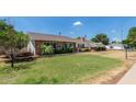 Charming single-story brick home with a well-manicured lawn and lush landscaping surrounding the property at 1407 E 1St St, Mesa, AZ 85203