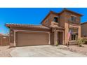 Two-story home with a two car garage, a desert rock yard and a quaint, covered entry way at 16284 W Desert Mirage Dr, Surprise, AZ 85379
