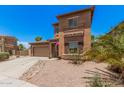 Two-story home with a two car garage, a desert rock yard and a quaint, covered entry way at 16284 W Desert Mirage Dr, Surprise, AZ 85379