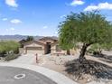 Charming front exterior featuring a desert landscape with mature trees, a driveway, and a two-car garage at 16404 S 18Th Dr, Phoenix, AZ 85045