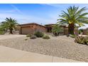 Charming single-story home featuring a desert landscape, two-car garage and a neutral color palette at 16716 W Rincon Peak Dr, Surprise, AZ 85387