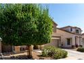 Attractive two-story home featuring a tile roof, neutral colors, and a meticulously maintained front yard at 17413 W Mandalay Ln, Surprise, AZ 85388