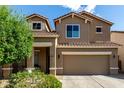 Inviting two-story home featuring a two-car garage, tile roof, neutral colors, and a manicured front yard at 17413 W Mandalay Ln, Surprise, AZ 85388