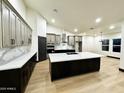 Modern kitchen with a large island, white marble countertops, stainless steel appliances, and modern cabinetry at 22504 W Meade Ln, Buckeye, AZ 85326