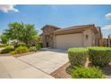 Well-maintained home with desert landscaping, a wide driveway, and an attached two-car garage at 22660 N 122Nd Ave, Sun City, AZ 85373