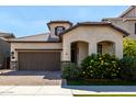 Inviting home featuring an attached garage, tile roof, and vibrant landscaping at 2716 S Chatsworth --, Mesa, AZ 85209
