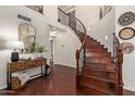 Bright foyer with a curved staircase, wood floors, and a decorative console table at 3089 E Indigo Bay Dr, Gilbert, AZ 85234
