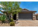 Charming single-story home with a two-car garage, desert landscaping, and a brick paver driveway at 31219 N 6Th Pl, Phoenix, AZ 85085