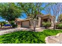 Charming home featuring well-manicured lawn, mature trees, and a two-car garage at 37911 N Luke Ln, San Tan Valley, AZ 85140