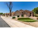Attractive single-story residence featuring a manicured lawn and an attached two-car garage at 42458 W Desert Fairways Dr, Maricopa, AZ 85138